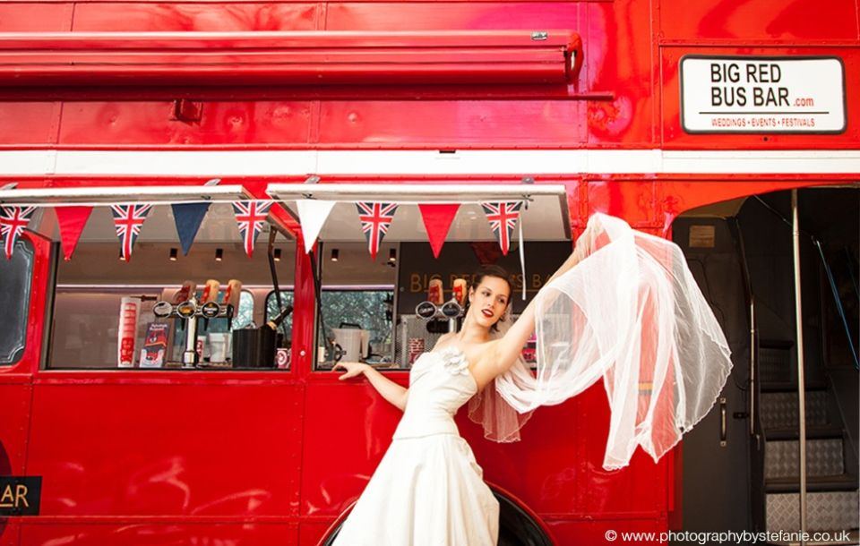Bride waving from the window of the bus bar